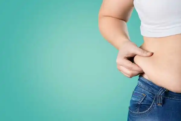 Image of woman pinching her love handles to show weight gain Feltham